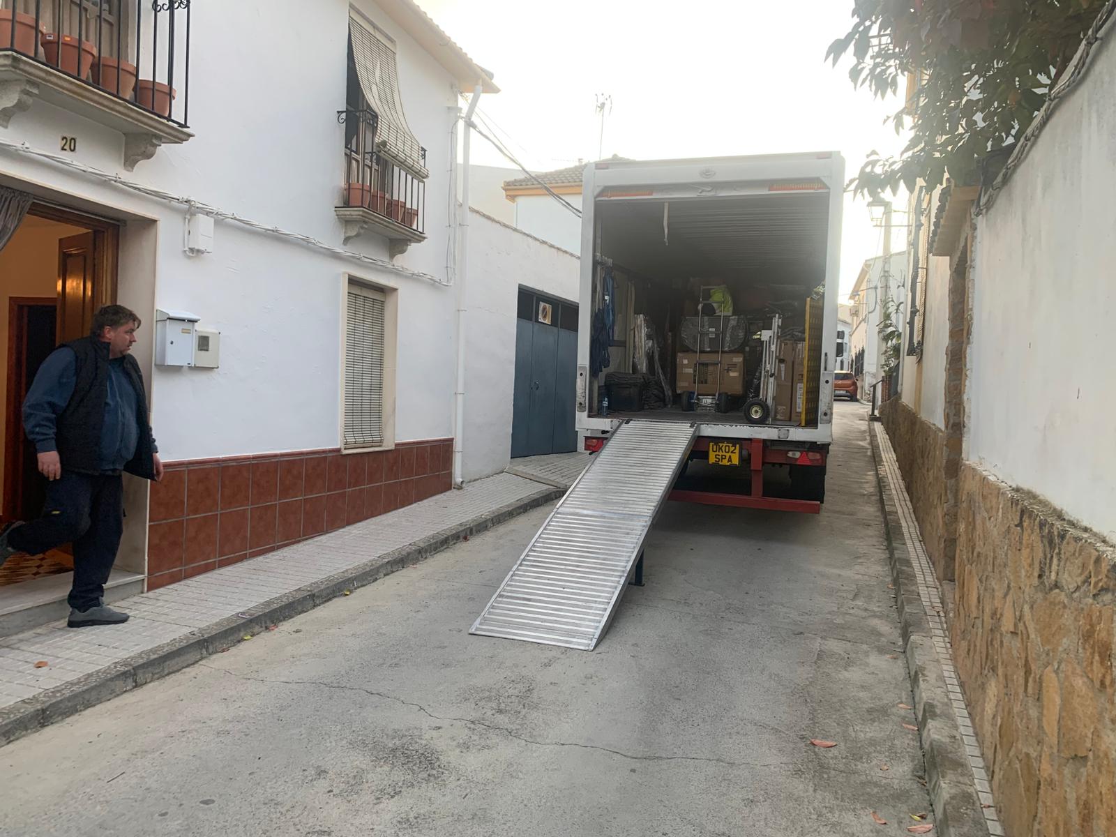 Transcone truck delivering household goods to a residential street in Spain